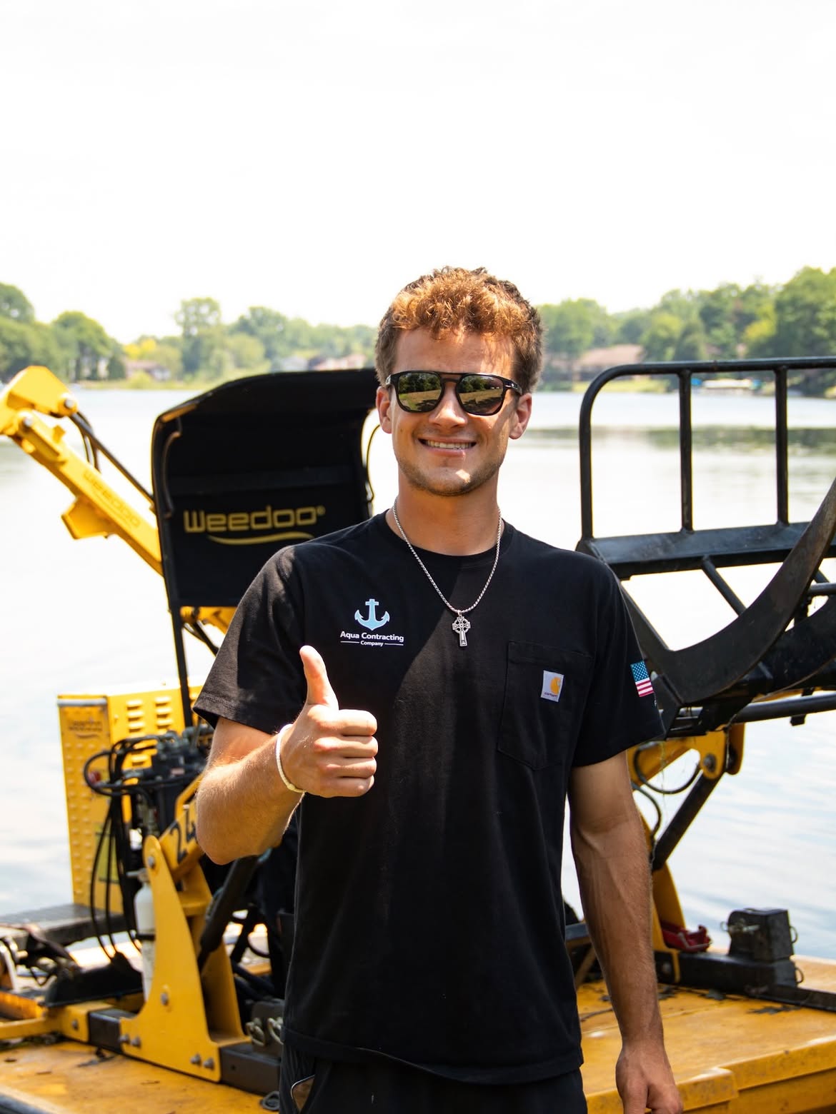 Shea, owner of Aqua Contracting Company, in front of the harvester